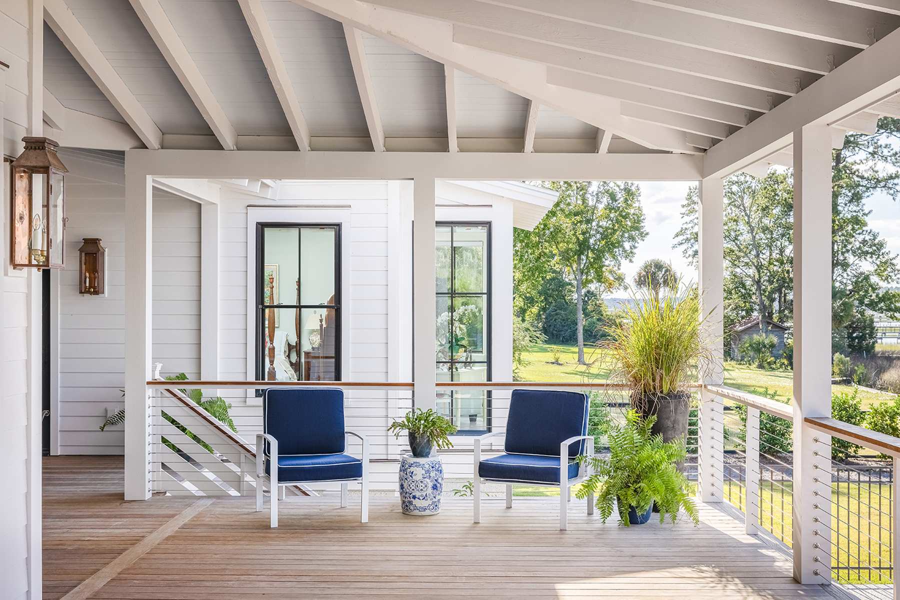 Back covered deck with patio chairs, overlooking the marsh