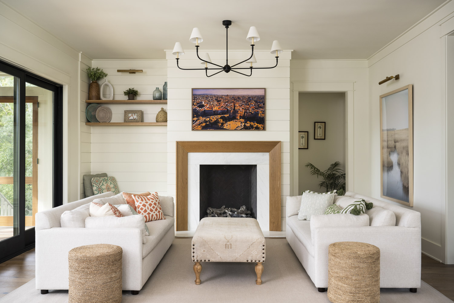 Living room Living room of custom home with shiplap walls, fireplace with wood surround, and white sofas and wicker side tables.