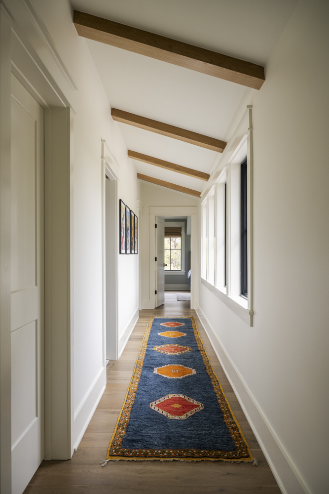 Hallway with slanted ceiling beams Upstairs hallway with slanted ceiling and wood beams