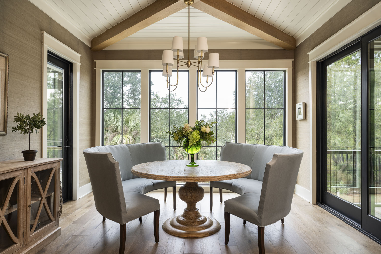 Dining room table Round dining room table overlooking the marsh. Exposed ceiling beams with shiplap ceiling and textured wallpaper.