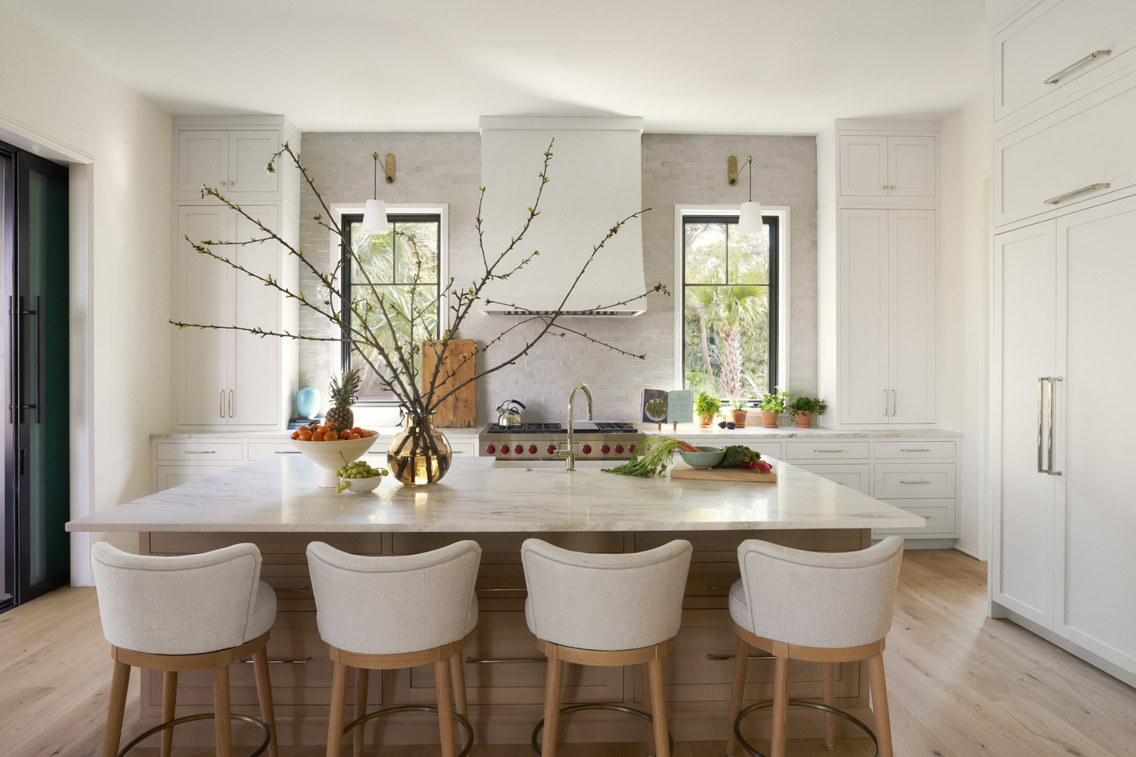 Sage-horizontal-kitchen Living room of custom home with shiplap walls, fireplace with wood surround, and white sofas and wicker side tables.