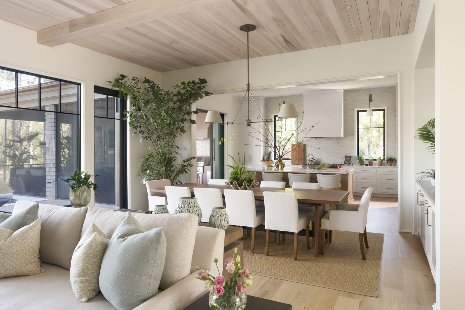 Sage-horizontal-living+kitchen Large kitchen island with green cabinetry and gold hardware accents